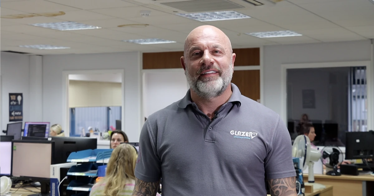 Rob Brearley, Group Managing Director of Glazerite, standing in an office environment with colleagues in the background