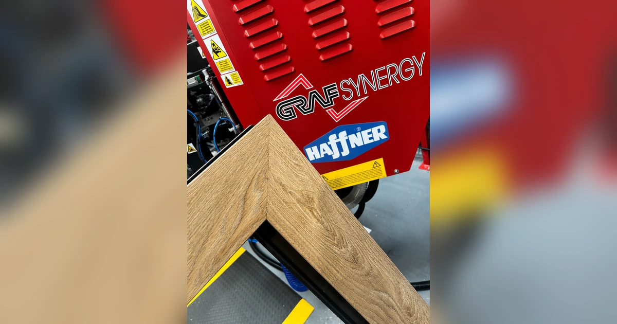 Red Graf Synergy welding machine with a close-up of a seamless welded PVC-U window frame corner in a workshop setting