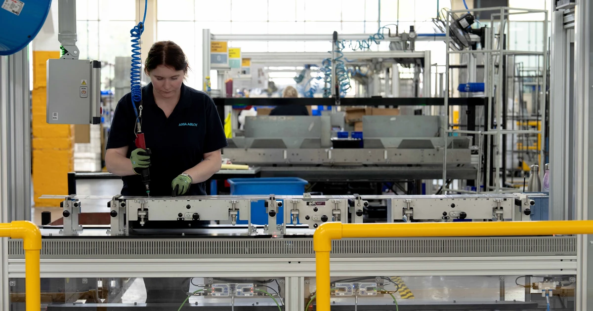 Worker operating machinery on the MOTUS multipoint lock manufacturing flowline in ASSA ABLOY's Willenhall facility
