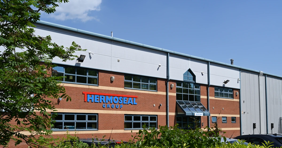 Exterior view of Thermoseal Group manufacturing and office building with clear blue sky and greenery