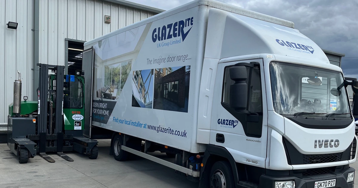 White Glazerite delivery truck parked outside warehouse under cloudy sky