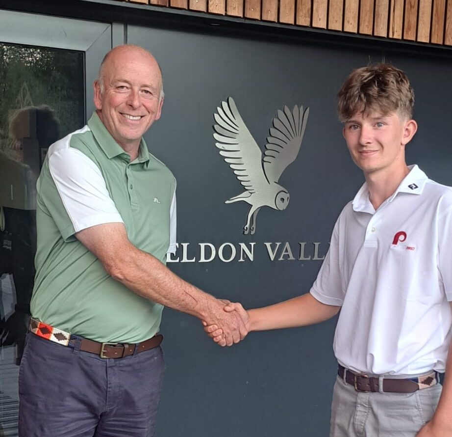 Joe Bowes and Isaac Hayes shaking hands in front of Feldon Valley golf club sign