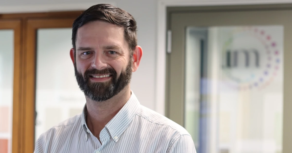 Kevin Jones, Technical Director at the Glass & Glazing Federation, smiling and standing indoors.